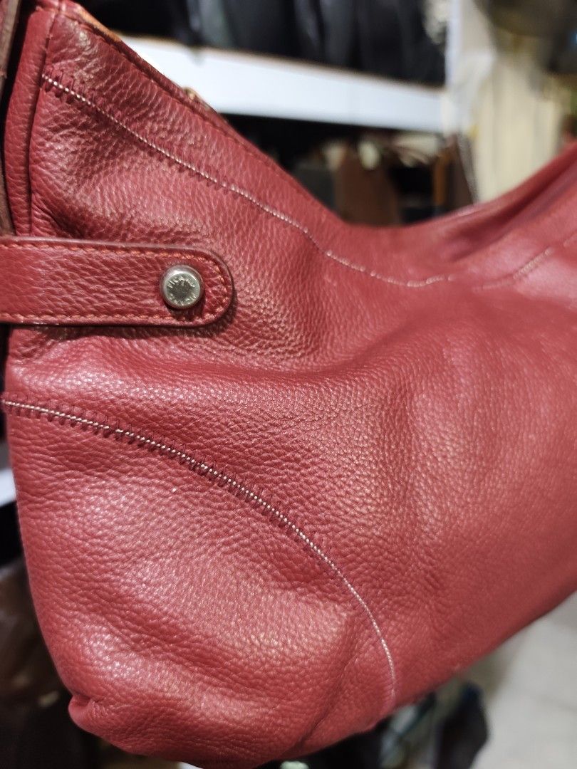 Picard Red Leather Shoulder Bag (Category: Luxury Bags & Wallets) located in Rizal. Submitted by chicout (Listing ID 1467617075, Image 2). Description: - Brand: Picard - Material: Soft pebble-textured red leather with contrast stitching - Hardware: Silver-tone with logo-stamped metal buttons and large side rings - Closure: Secure top zip - Interior: Cream fabric lining with a zippered pocket and brand logo plaque - Exterior: Convenient back zippe