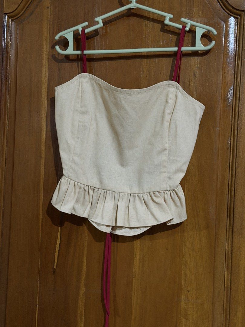 Pilya Beige Crop Top with Red Straps (Category: Sleeveless) located in Caloocan City. Submitted by sisi_p (Listing ID 1467655724, Image 1). Description: - Brand: Pilya - Size: XS - Color: Beige with deep red spaghetti straps - Design: Ruffled hem at bottom and back, open-back with tie closure.