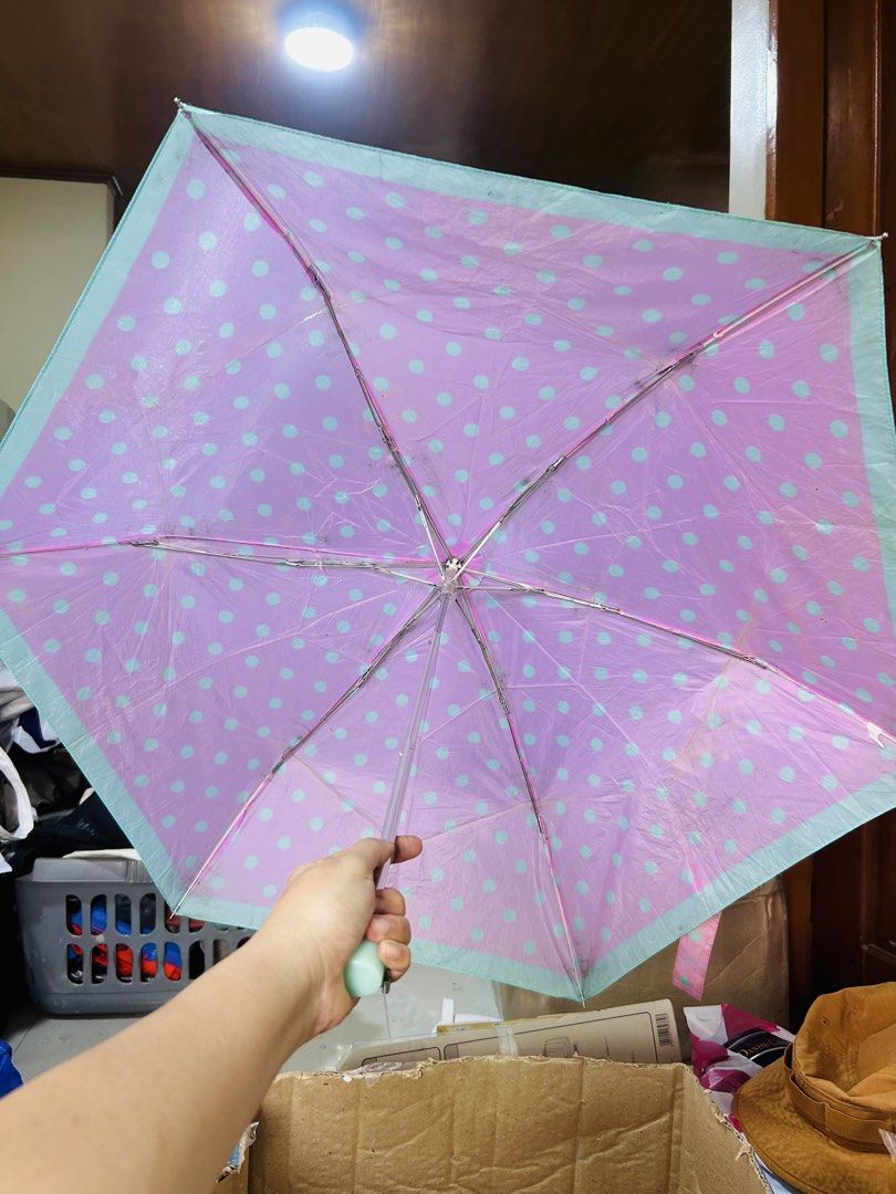 Pink and blue polka dot folding umbrella (Category: Umbrellas) located in Manila. Submitted by starbalesukandjapansurplus (Listing ID 1467659503, Image 3). Description: - Color: Bright pink with light blue polka dots and teal trim - Design: Compact folding umbrella with matching handle and snap strap closure - Coverage: Opens into a good-sized canopy to keep you dry - Condition: Some slight wear on the ribs and fabric from regular use - Perfect f