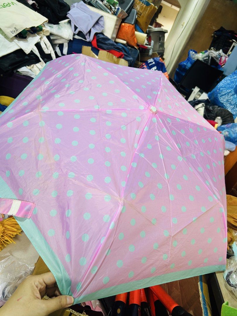 Pink and blue polka dot folding umbrella (Category: Umbrellas) located in Manila. Submitted by starbalesukandjapansurplus (Listing ID 1467659503, Image 2). Description: - Color: Bright pink with light blue polka dots and teal trim - Design: Compact folding umbrella with matching handle and snap strap closure - Coverage: Opens into a good-sized canopy to keep you dry - Condition: Some slight wear on the ribs and fabric from regular use - Perfect f