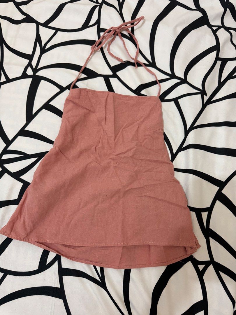 Pink halter top with adjustable tie straps (Category: Sleeveless) located in Bulacan. Submitted by alshopie (Listing ID 1467639235, Image 1). Description: - Color: Dusty pink - Style: Halter top with thin tie straps and straight neckline - Fit: Relaxed fit with a slight high-low hem - Fabric: Lightweight and breathable - Condition: Excellent, no stains or loose threads - Perfect for: Pairing with denim shorts or skirts for warm weather.