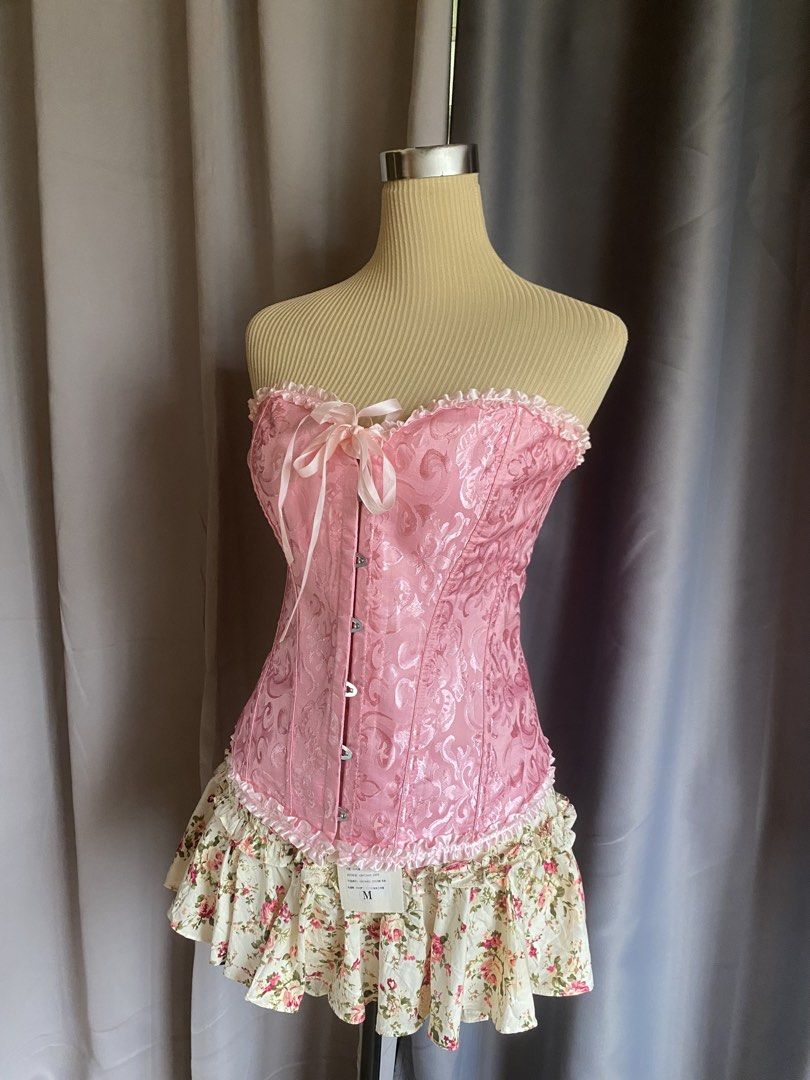 Pink Lace Up Corset Top (Category: Sleeveless) located in Cagayan de Oro. Submitted by curated_closetph (Listing ID 1467764348, Image 2). Description: — Size : M - L — Color: Pink — Textured brocade fabric with subtle floral satin patterns — Strapless sweetheart neckline accented with a ruffled lace trim — Front busk closure with silver metal hooks for easy wear — Traditional adjustable ribbon lace-up back to tighten or loosen the fit — Full stru
