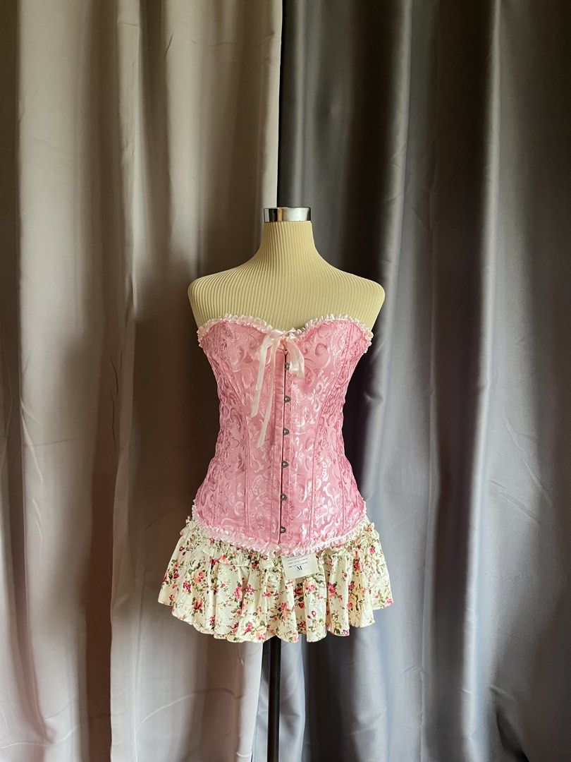 Pink Lace Up Corset Top (Category: Sleeveless) located in Cagayan de Oro. Submitted by curated_closetph (Listing ID 1467764348, Image 1). Description: — Size : M - L — Color: Pink — Textured brocade fabric with subtle floral satin patterns — Strapless sweetheart neckline accented with a ruffled lace trim — Front busk closure with silver metal hooks for easy wear — Traditional adjustable ribbon lace-up back to tighten or loosen the fit — Full stru