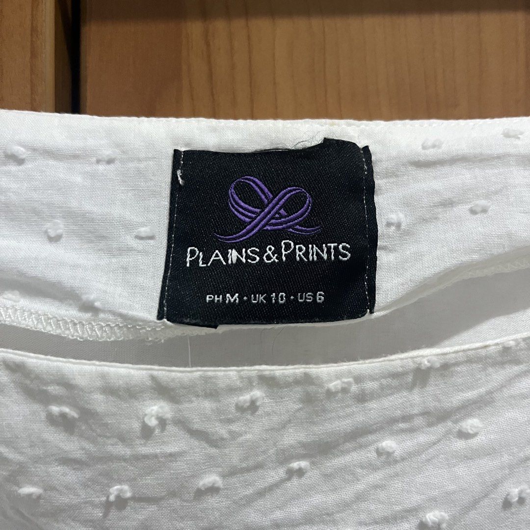 Plains & Prints White Long Sleeve Blouse Size M (Category: Longsleeves) located in Makati City. Submitted by possession.ph (Listing ID 1467782743, Image 2). Description: - Brand: Plains & Prints - Color: White - Size: PH M / UK 10 / US 6 - Design: Square neckline, textured dots, and scalloped hem details - Sleeves: Ruched with adjustable drawstrings - Minor Flaw: Has yellowing stains on the sleeves. Please see last picture. .