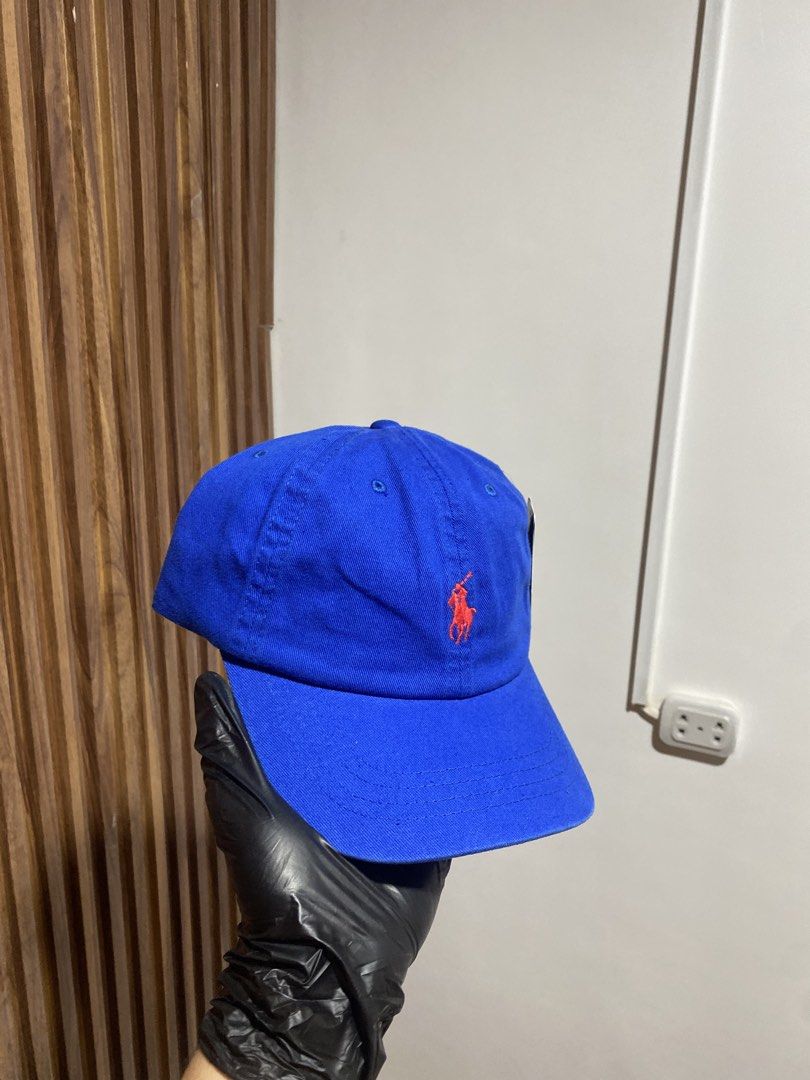 Polo Ralph Lauren Royal Blue Cap (Category: Caps & Hats) located in Caloocan City. Submitted by heatedcaps4425 (Listing ID 1467804346, Image 2). Description: - Brand: Polo Ralph Lauren - Color: Royal blue with bright red accents - Details: Embroidered red pony logo on front, red POLO lettering above back strap - Fit: Adjustable metal buckle closure - Condition: Brand new with tags attached.