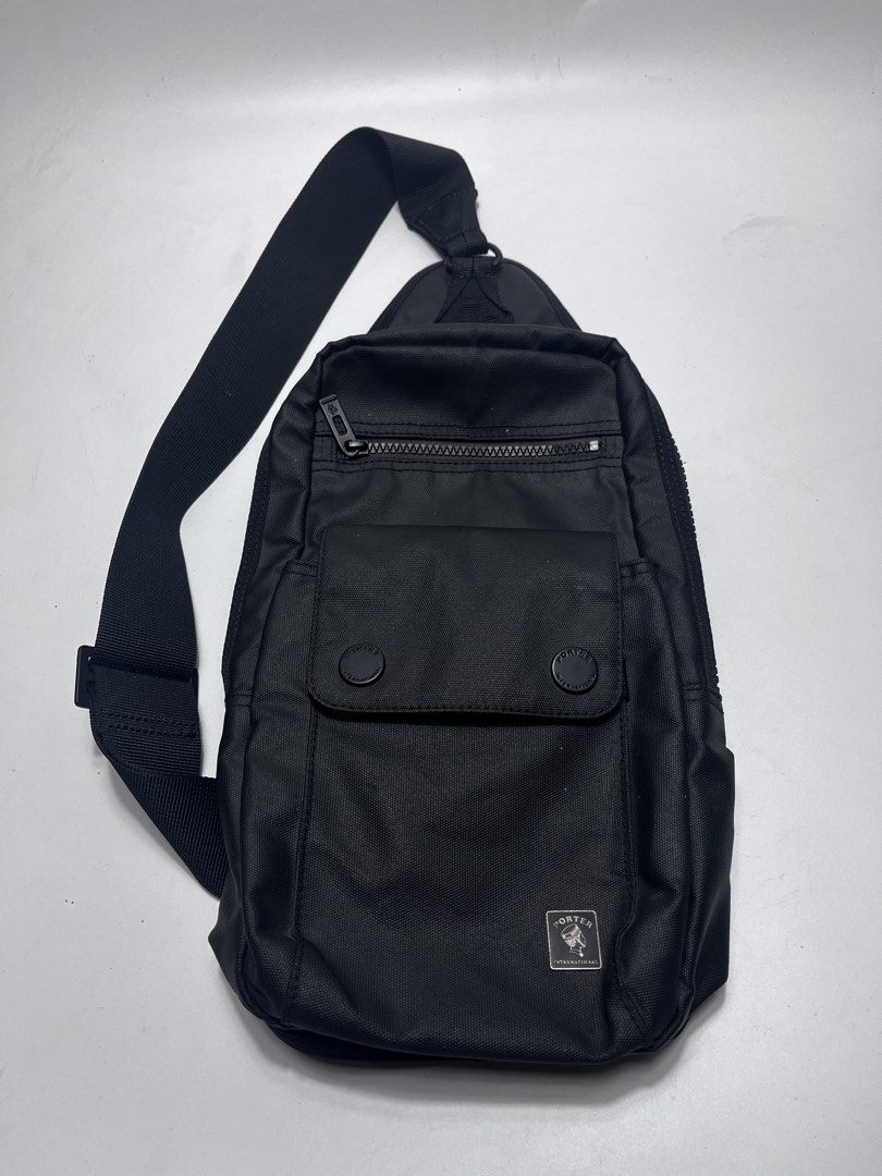 Porter International Black Sling Bag (Category: Sling Bags) located in Iloilo. Submitted by fromthebins.ilo2 (Listing ID 1467751222, Image 3). Description: - Brand: Porter International - Color: Solid Black - Material: Durable, structured nylon - Compartments: Main compartment with multiple interior/side zip pockets - Exterior Pockets: Front flap pocket with snap buttons and an extra zip pouch - Strap: Adjustable shoulder strap with sturdy hardwa