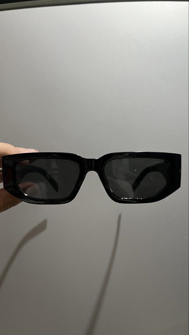Prada Black Rectangular Sunglasses (Category: Sunglasses & Eyewear) located in Manila. Submitted by _jeanno (Listing ID 1467658395, Image 1). Description: - Brand: Prada - Color: Black with dark tinted lenses - Frame: Thick rectangular, modern minimalist style - Details: Signature gold triangular logo plaque on temple arms - Condition: Clean shape, ready to wear.