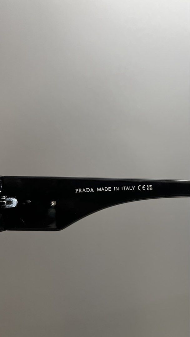 Prada Black Rectangular Sunglasses (Category: Sunglasses & Eyewear) located in Manila. Submitted by _jeanno (Listing ID 1467658395, Image 3). Description: - Brand: Prada - Color: Black with dark tinted lenses - Frame: Thick rectangular, modern minimalist style - Details: Signature gold triangular logo plaque on temple arms - Condition: Clean shape, ready to wear.
