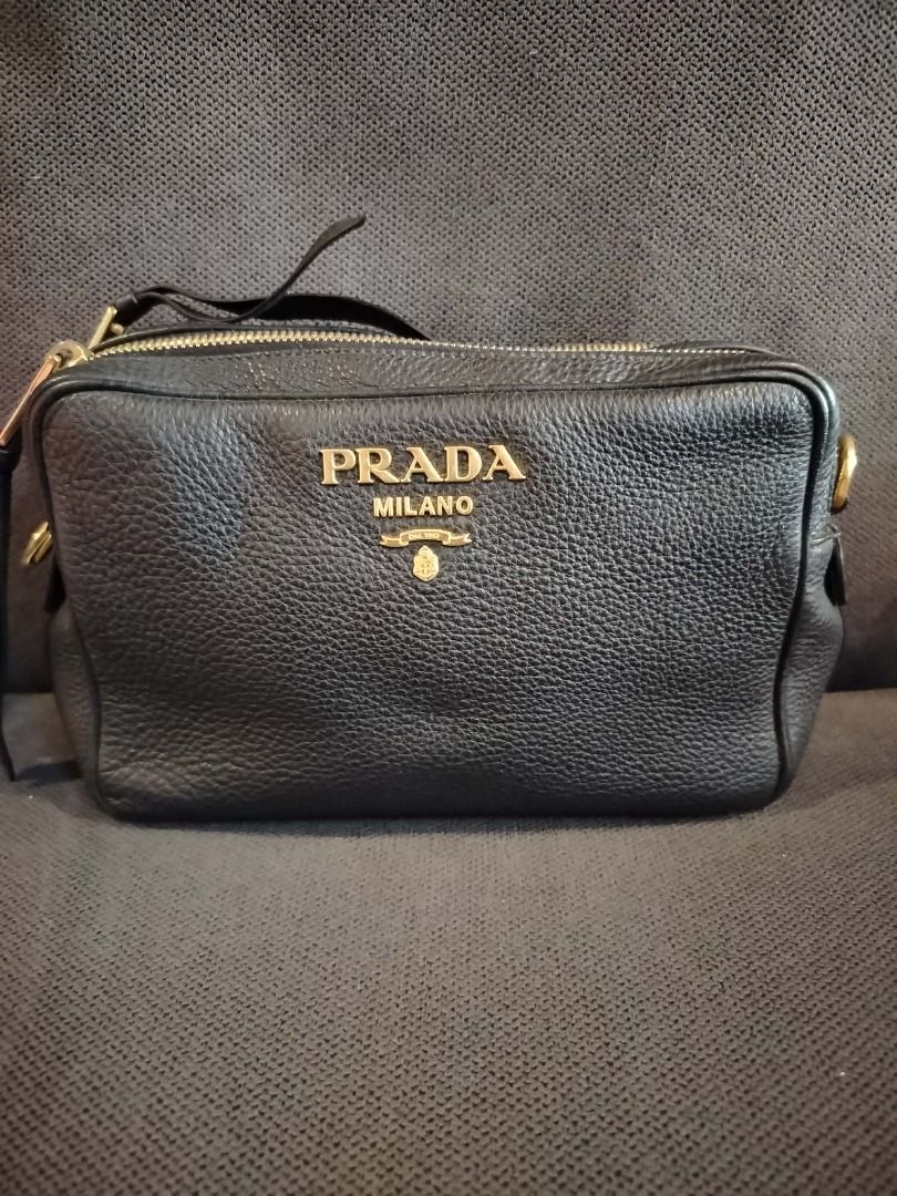 Prada Milano Vitello Daino Camera Bag Black (Category: Luxury Bags & Wallets) located in Caloocan City. Submitted by luxesavvy63110 (Listing ID 1467770716, Image 1). Description: Preloved authentic Prada camera bag in black pebbled leather with gold-tone Prada Milano lettering and double zip top. Structured and easy to style. Meetup or shipping available..