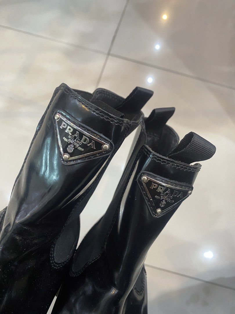 Prada Monolith Brushed Leather Chelsea Boots (Category: Boots) located in Cavite. Submitted by frankiemnla (Listing ID 1467613250, Image 2). Description: • Like new condition • Model: Monolith Brushed Leather Chelsea Boots • Key Features: Glossy brushed leather finish, thick lugged rubber platform sole, elastic side panels, back pull tabs, and the signature enameled metal triangular Prada logo plaque on the shaft..
