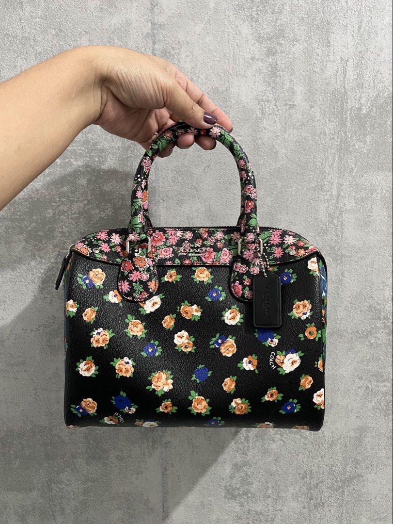 Preloved Auth 💯Coach Floral Print Bennett Black (Category: Luxury Bags & Wallets) located in Calamba. Submitted by thedreambags.ph (Listing ID 1467612420, Image 1). Description: - Brand: Coach - Design: Vibrant colorful floral print on black base with striking blue rose side panels - Hardware & Details: Black leather hangtag included - Features: Dual rolled carrying handles, secure top zip closure, and structured flat bottom for stability - Cond