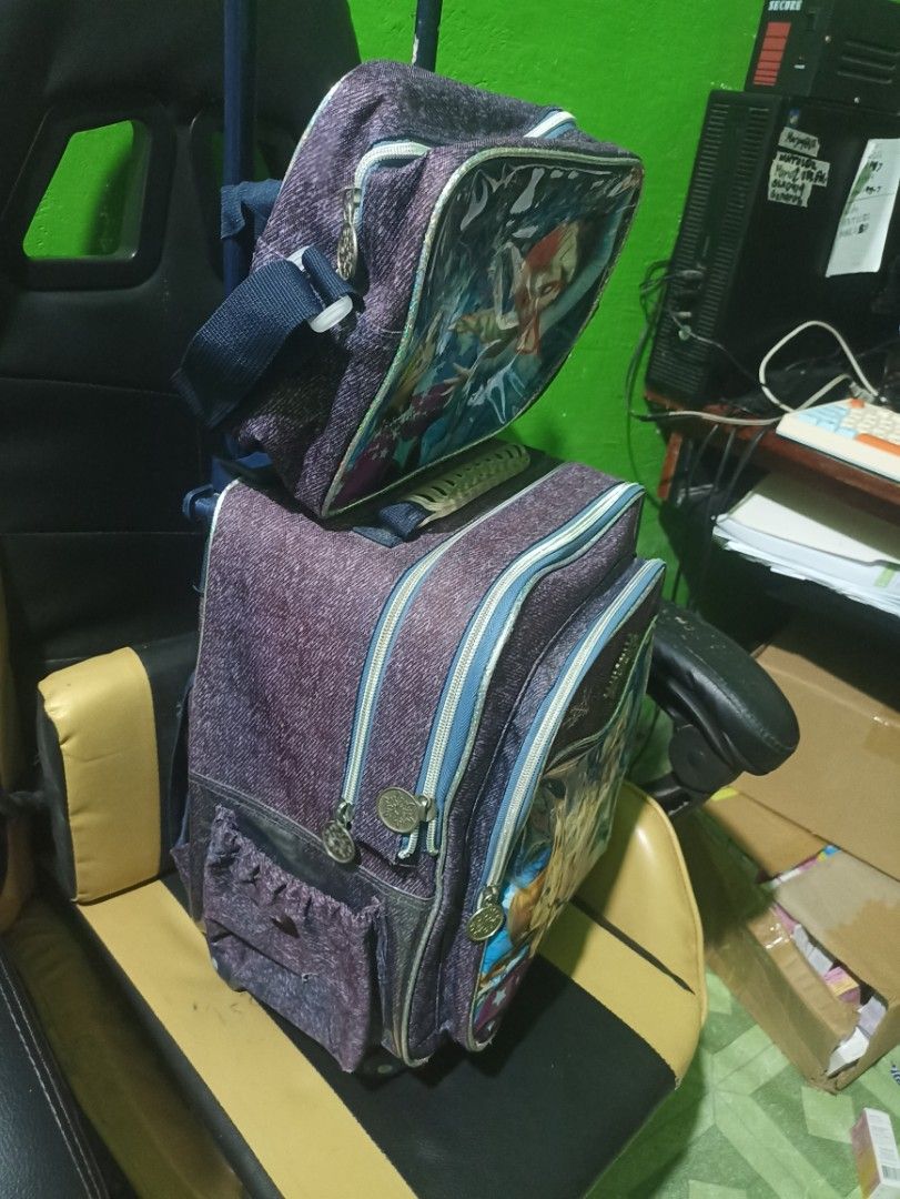 Preloved Frozen Roller Backpack and Lunch Bag Set (Category: Backpacks) located in Tarlac. Submitted by allinoneshop2178 (Listing ID 1467726279, Image 2). Description: - Official Frozen design featuring Anna and Elsa on purple denim-look fabric - Complete 2-in-1 set: rolling school bag and matching lunch bag - Lunch bag conveniently attaches to the main trolley handle - Smooth-rolling durable wheels with a sturdy telescopic handle - Spacious zipp