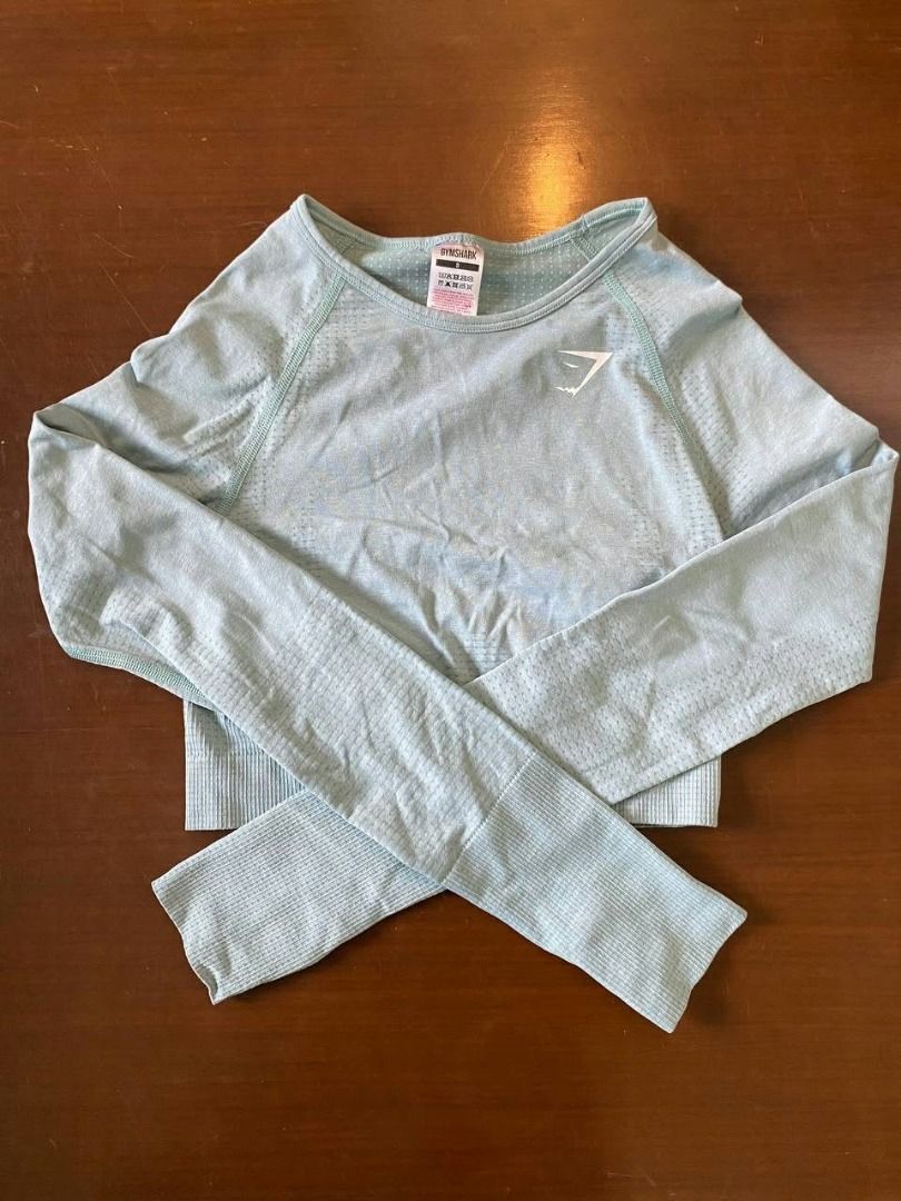 Preloved Gymshark Top Blue S (Category: Longsleeves) located in Muntinlupa City. Submitted by irene.aragon.navarro (Listing ID 1467670625, Image 1). Description: - Brand: Gymshark - Style: Long sleeve crop top - Color: Light blue - Size: Small - Material: Seamless knit with textured patterns - Features: Ribbed cuffs and white heat-sealed chest logo - Condition: Great for gym, running, or casual wear.