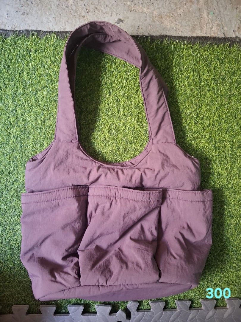 Puffy shoulder bag in dusty purple (Category: Shoulder Bags) located in Pasay City. Submitted by emilia1102 (Listing ID 1467789170, Image 2). Description: - Color & Material: Dusty purple soft nylon with a chic quilted texture - Storage: Roomy main compartment for daily essentials plus 3 large front pockets - Comfort: Wide straps designed for comfortable shoulder wear - Style: Lightweight and casual, perfect for everyday use.