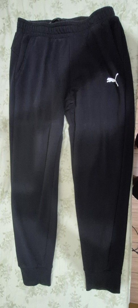 Puma Black Sweatpants Size L (Category: Joggers) located in Marikina City. Submitted by raesales (Listing ID 1467711997, Image 1). Description: - Brand: Puma - Color: Black - Size: Large (L) - Style: Classic athletic joggers with elastic waistband and ribbed cuffs - Detail: White Puma logo printed on the left thigh - Material: 100% cotton - Style Number: 586718-01 (verified on inner label) - Origin: Made in Cambodia.