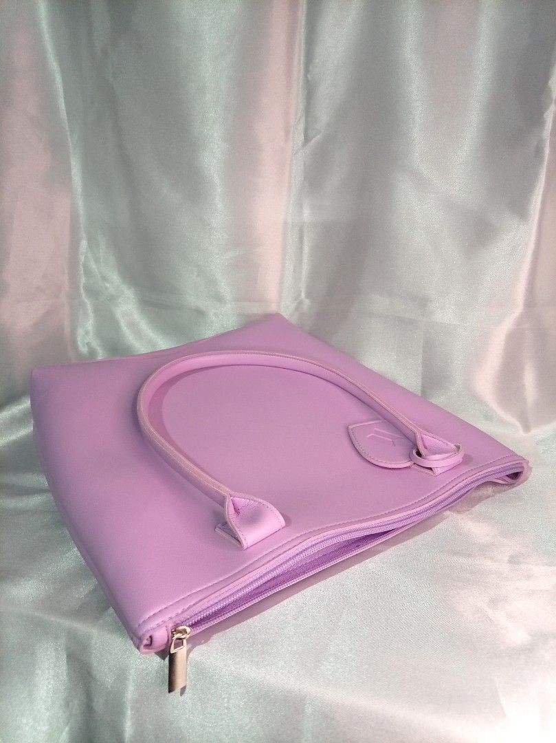 Purple BTS Heart Accent Tote Bag (Category: Tote Bags) located in Manila. Submitted by btsinpurple (Listing ID 1467691716, Image 3). Description: - Color: Light purple - Material: Smooth synthetic leather - Closure: Top zipper with matching pull - Inclusion: Heart-shaped BTS logo bag charm - Features: Twin carry handles and clean solid interior lining - Capacity: Roomy size perfect for daily essentials - Quality: Neat stitching along all seams an