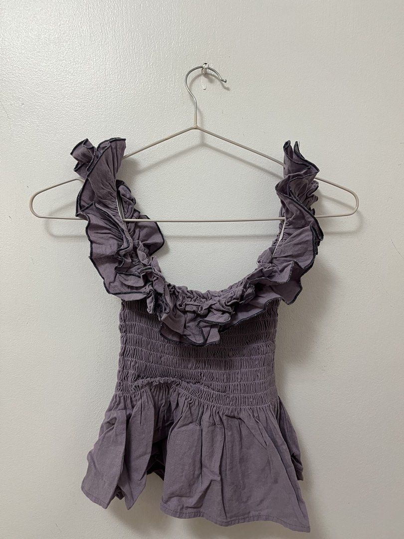 Purple Ruffle Off-Shoulder Smocked Blouse (Category: Blouses) located in Batangas. Submitted by povofkbscloset (Listing ID 1467671420, Image 2). Description: - Color: Dusty purple - Details: Ruffles around neckline and shoulders, flared peplum hem - Fit: Smocked body that stretches nicely - Condition: Worn once, still looks great - Styling: Pairs easily with high-waisted pants or jeans.