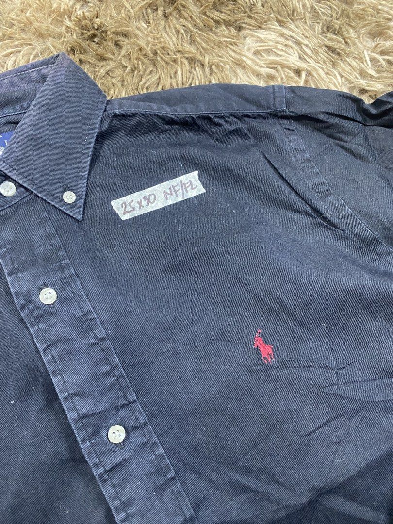 Ralph Lauren Button Down Shirt Navy Size M (Category: Tshirts & Polo Shirts ) located in Cagayan de Oro. Submitted by sepamorash53558 (Listing ID 1467642437, Image 2). Description: - Brand: Ralph Lauren - Style: Long sleeve button-down shirt with classic collar and front button closure - Color: Navy blue with red embroidered pony logo on the chest - Material: 100% cotton - Size: Medium (Tag attached) - Measurements: 25" x 30" - Condition: Shows n