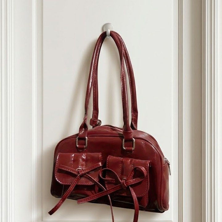 Red Patent Leather Handbag with Bow Details (Category: Luxury Bags & Wallets) located in Batangas. Submitted by izhcorpuz (Listing ID 1449362992, Image 1). Description: - Adorable red patent leather handbag - Two front pockets with charming bow tie closures - Secure zipper closure on top - Comfortable double handles - Eye-catching shiny finish - Versatile for everyday wear or evening outings.