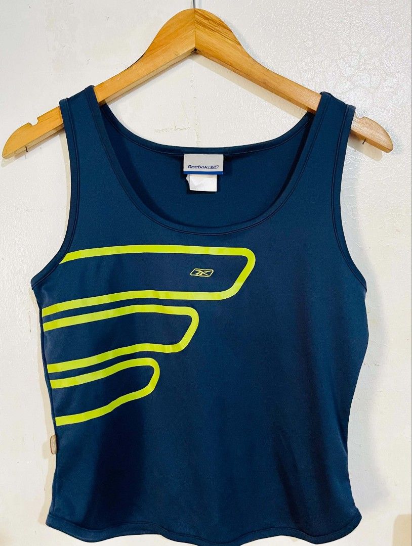 Reebok Tank Top (Category: Sleeveless) located in San Mateo. Submitted by safeearth21 (Listing ID 1467795557, Image 2). Description: - Brand: Reebok - Color: Navy blue with bright green graphic lines and logo - Size: Small (tagged at collar) - Neckline: Scoop neck - Material: Breathable athletic fabric - Condition: Great piece for workouts or casual streetwear.