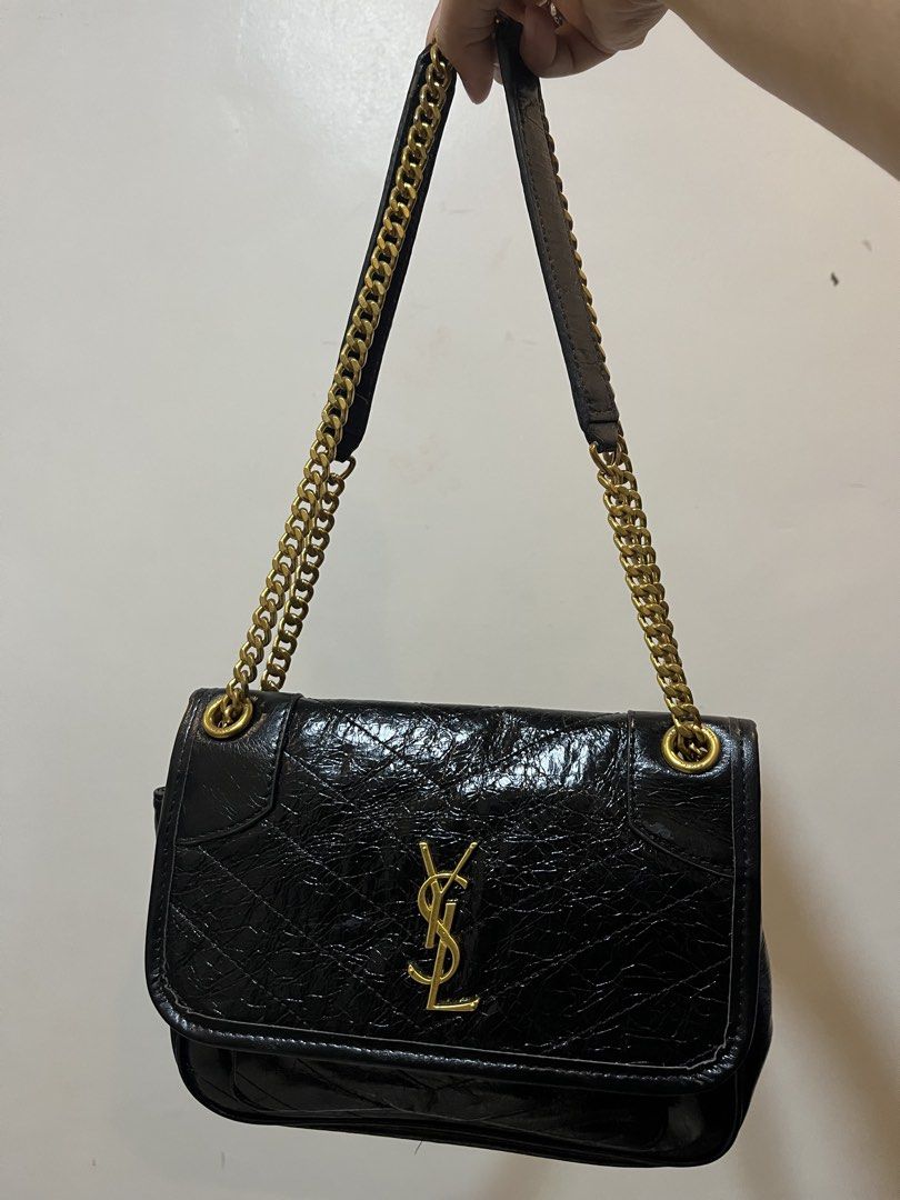 Saint Laurent Black Crinkled Leather Shoulder Bag (Category: Shoulder Bags) located in Bacolod City. Submitted by vintage_vogue6100 (Listing ID 1467760121, Image 2). Description: Black crinkled leather shoulder bag from Saint Laurent. Antique gold-tone hardware, iconic YSL logo on the front flap. Chain strap with leather comfort pad. Magnetic snap closure. Interior zipped pocket and fabric lining. Approximate dimensions: 25cm length, 18cm height,