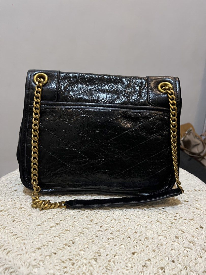 Saint Laurent Black Crinkled Leather Shoulder Bag (Category: Shoulder Bags) located in Bacolod City. Submitted by vintage_vogue6100 (Listing ID 1467760121, Image 3). Description: Black crinkled leather shoulder bag from Saint Laurent. Antique gold-tone hardware, iconic YSL logo on the front flap. Chain strap with leather comfort pad. Magnetic snap closure. Interior zipped pocket and fabric lining. Approximate dimensions: 25cm length, 18cm height,