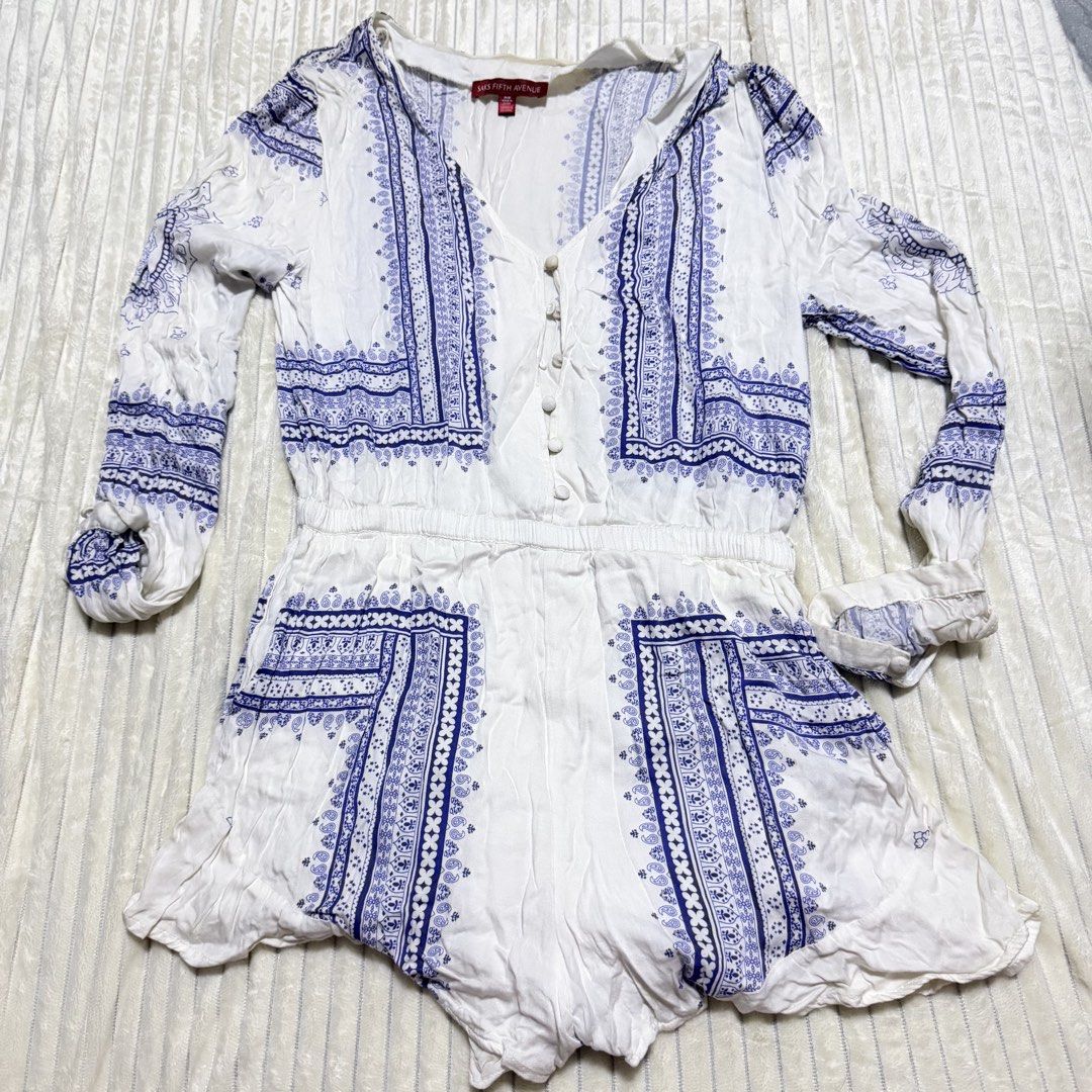 Saks Blue White Pattern Long Sleeve Romper (Category: Rompers) located in Manila. Submitted by ish.cakes (Listing ID 1467741768, Image 1). Description: - Brand: Saks Fifth Avenue - Style: White and blue printed romper with shorts and stylish side panels - Fit: Comfortable elastic waistband for easy wear - Size M - Details: Long sleeves with front button placket - Fabric: Lightweight and breathable, ideal for warm weather - Condition: Preloved; Us