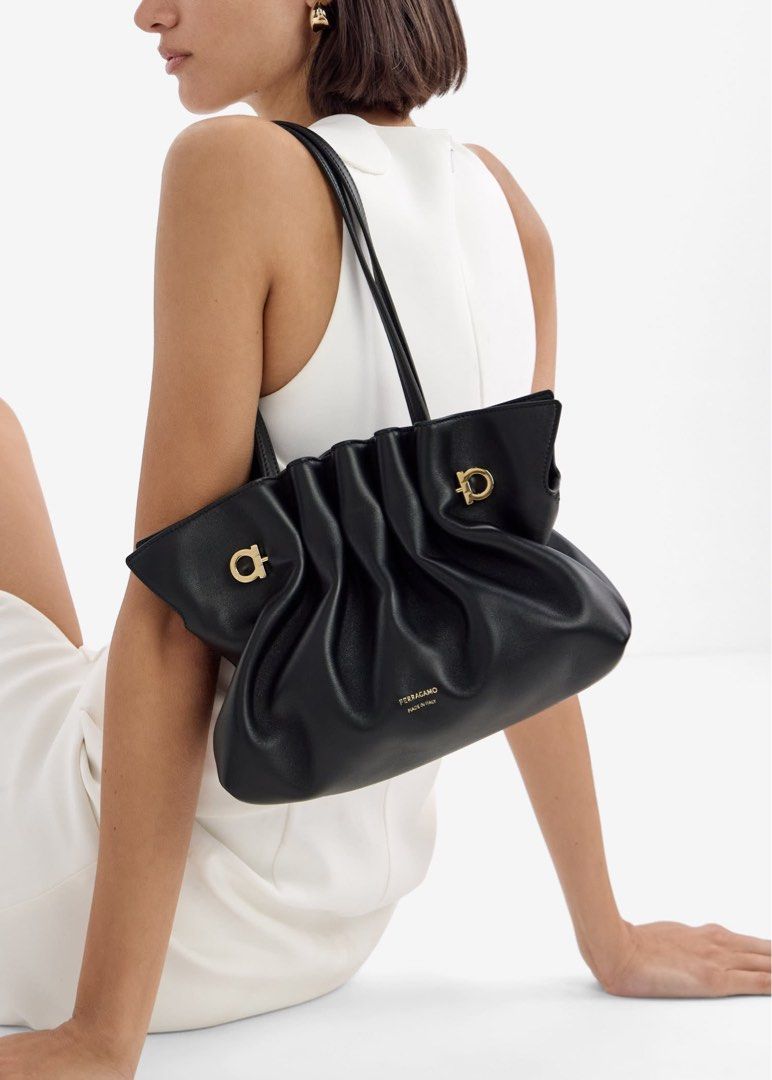 Salvatore Ferragamo Black Leather Shoulder Bag (Category: Luxury Bags & Wallets) located in Abulug. Submitted by jamiecammie (Listing ID 1467645376, Image 1). Description: Black leather shoulder bag by Salvatore Ferragamo. Made in Italy. Soft, pleated design with gold-tone hardware details. Includes dual top handles, an adjustable leather crossbody strap, and a decorative Gancini chain link strap. Stamped gold Ferragamo logo on the front. Clean i