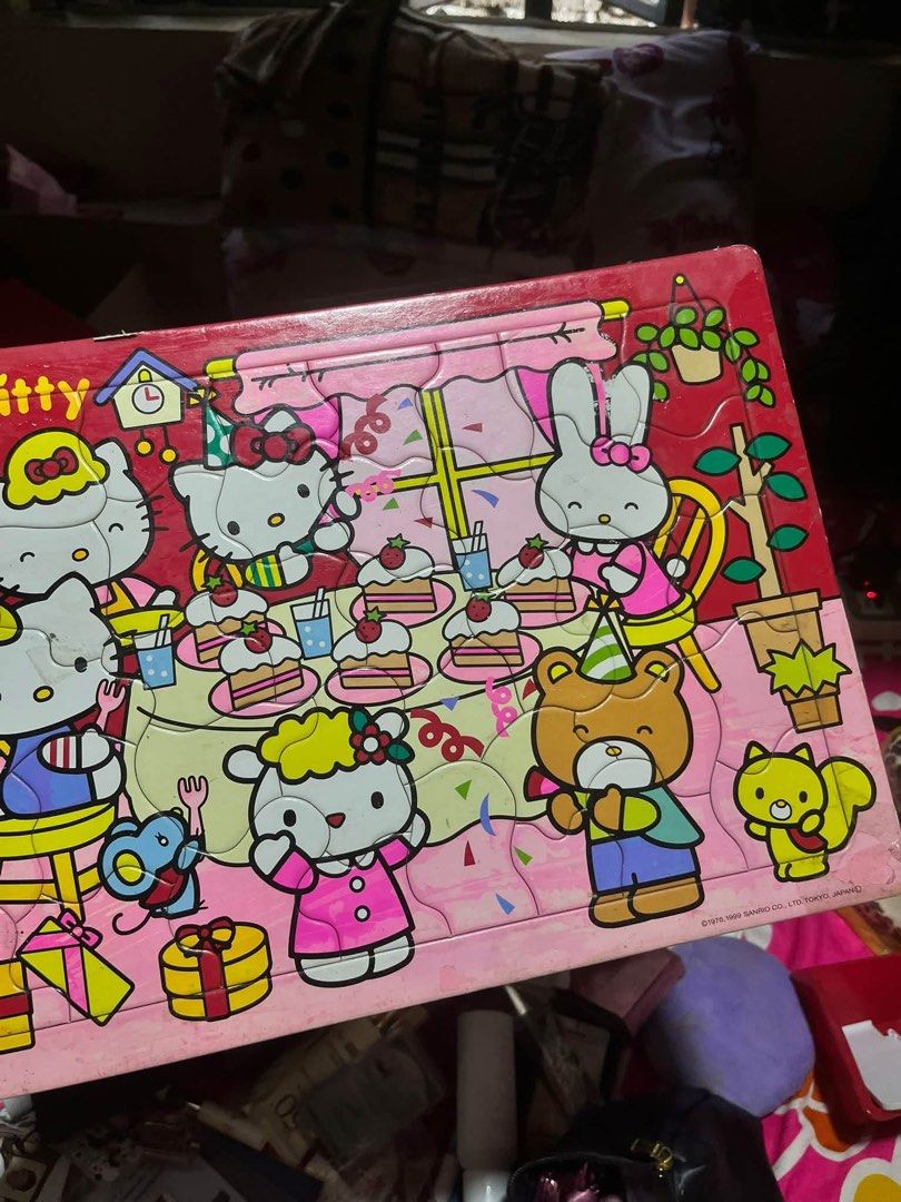 Sanrio Hello Kitty Vintage Jigsaw Puzzle (Category: Board Games & Puzzles) located in Manila. Submitted by janetecson05 (Listing ID 1467617906, Image 2). Description: - Vintage Sanrio Kitty wooden tray puzzle - Features a cute birthday party scene with lots of characters, cakes, gifts, and balloons - Pastel pink theme with official 1976 and 1999 copyright dates - Fun activity for kids or collectors of vintage cartoon merchandise.