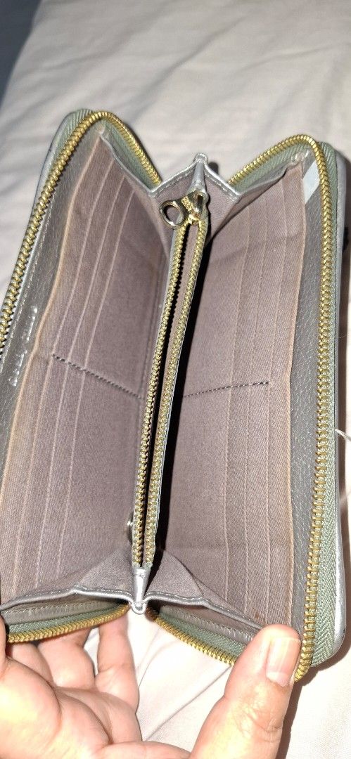See By Chloe Metallic Silver Zip Around Wallet (Category: Wallets & Card holders) located in Paranaque City. Submitted by finders_thriftersph (Listing ID 1467736954, Image 3). Description: Metallic silver textured leather wallet from See By Chloe. Wrap-around zipper closure with a matching leather tassel pull attached. Gold tone hardware details and embossed branding on the front plate and interior. Fabric lined compartments inside with multiple 