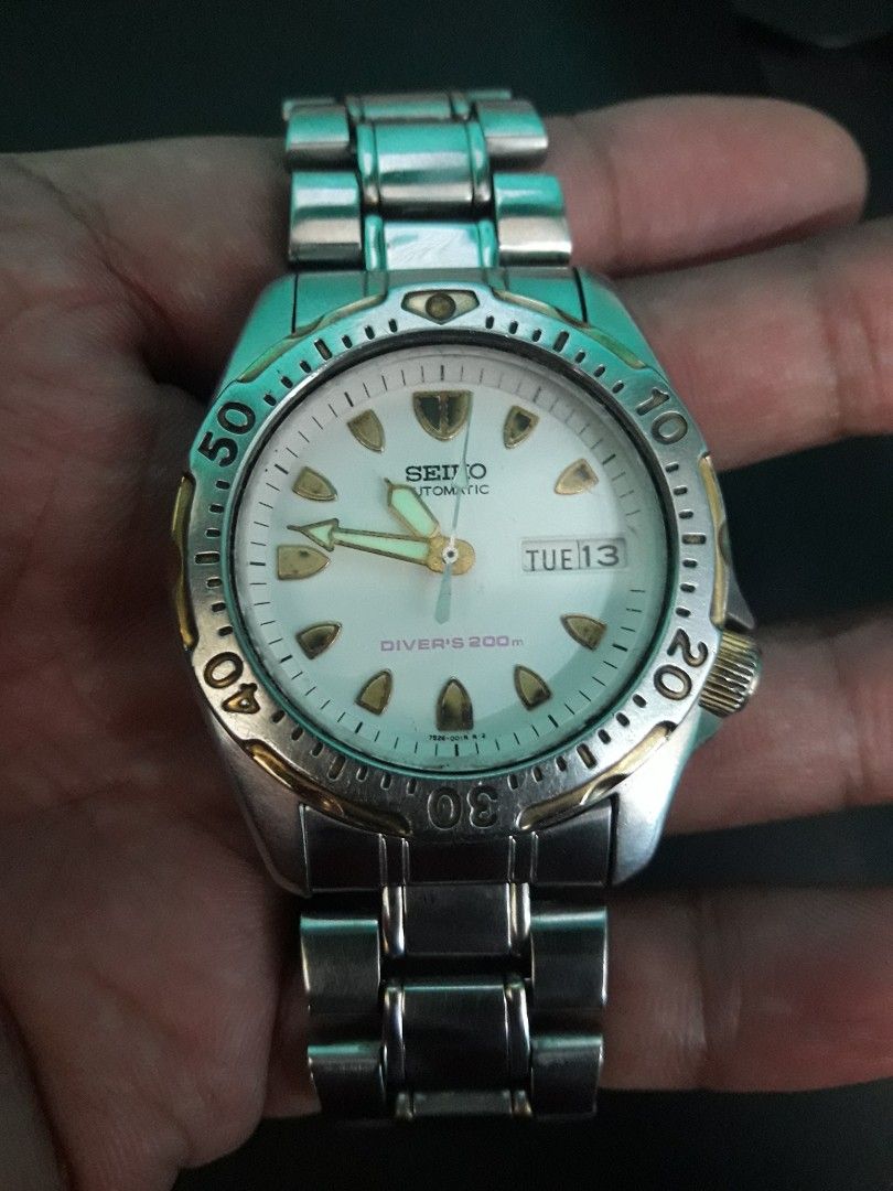 Seiko Automatic Scuba Diver's 200m Watch 7S26-0010 (Category: Men's Watches) located in Paranaque City. Submitted by omaraguirre (Listing ID 1467673327, Image 3). Description: - Brand/Model: Seiko Automatic Dive Watch - Dial & Bezel: White dial with gold accents on the bezel and crown - Features: Day-date window at 3 o'clock, rotating bezel - Hardware: Silver-tone metal bracelet with Seiko-branded deployment clasp, stainless steel case back with 