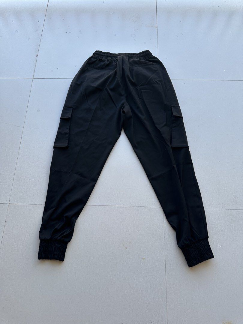 Sevenselah Black Cargo Jogger Pants (Category: Joggers) located in Manila. Submitted by royal_vintage_thriftshop (Listing ID 1467665939, Image 2). Description: - Color: Black - Style: Utility cargo joggers / Streetwear - Waistband: Elastic with matching drawstring - Pockets: Side flap pockets on both legs and two rear pockets - Hem: Cured elastic cuffs at the ankles - Material: Lightweight and easy to move in - Condition: Brand new / Excellent qu