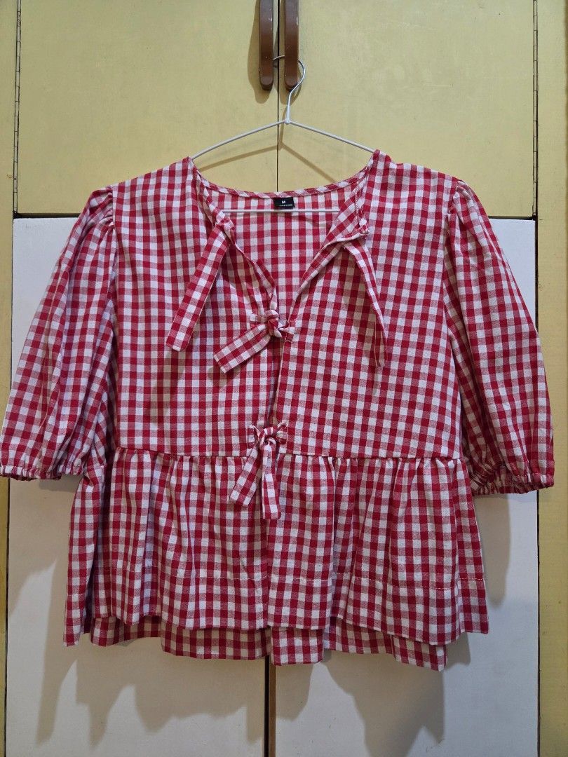 SHEIN Red & White Gingham Tie-Front Peplum Blouse (Size M) (Category: Blouses) located in Paranaque City. Submitted by mauandchelliedeclutters (Listing ID 1467781184, Image 1). Description: -super cute SHEIN Red Gingham Plaid Top in size M -​red and white gingham pattern, tie-front bow detail, babydoll peplum hem. -easy to pair with high-waisted shorts or denim ​ ​Brand: SHEIN ​Size: Medium (Tag size M) ​Condition: Excellent condition (No stains,