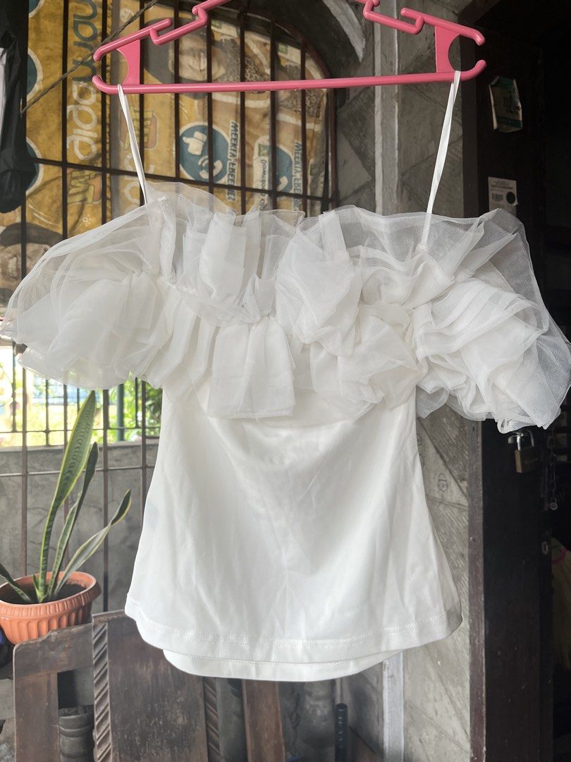 Shein White Ruffle Tulle Off Shoulder Top (Category: Sleeveless) located in Alitagtag. Submitted by jaaaimr (Listing ID 1467677028, Image 1). Description: - Brand: Shein - Size: S (EU 36, US 4) - Color: White - Design: Off-shoulder with layered sheer mesh ruffle details on chest and sleeves - Condition: Used once with no damage.