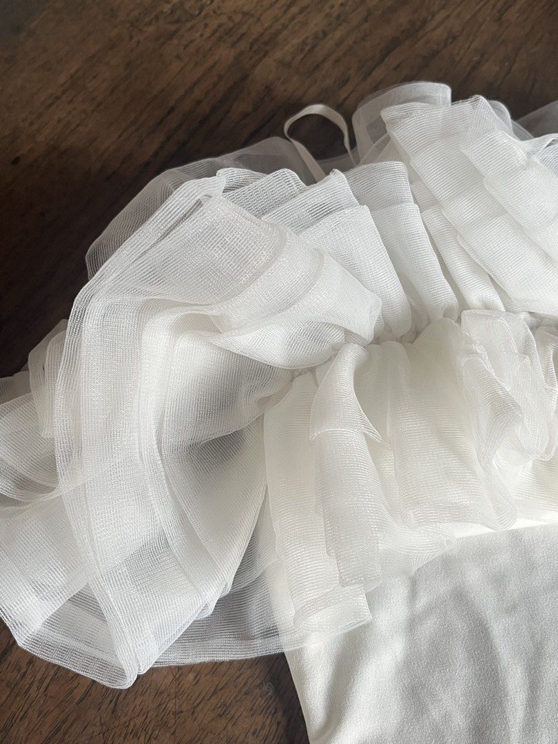 Shein White Ruffle Tulle Off Shoulder Top (Category: Sleeveless) located in Alitagtag. Submitted by jaaaimr (Listing ID 1467677028, Image 3). Description: - Brand: Shein - Size: S (EU 36, US 4) - Color: White - Design: Off-shoulder with layered sheer mesh ruffle details on chest and sleeves - Condition: Used once with no damage.