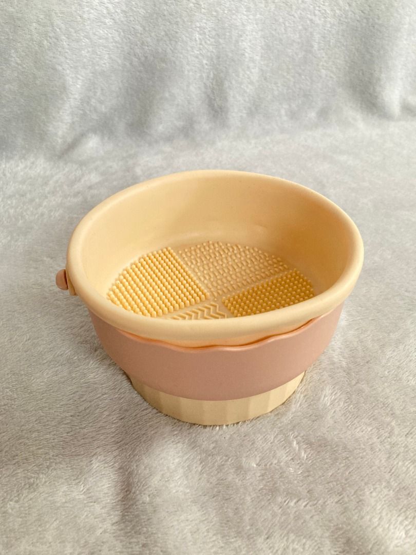 Silicone Makeup Brush Cleaner Folding Bowl (Category: Makeup) located in Rizal. Submitted by sheeraay (Listing ID 1467706031, Image 2). Description: - Color: Pink and beige - Material: Flexible silicone - Textured base with multi-pattern design for deep cleaning various brush sizes - Collapsible design folds flat for compact storage and travel - Handy side handle for easy grip and control - Quick and efficient way to wash your makeup brushes.