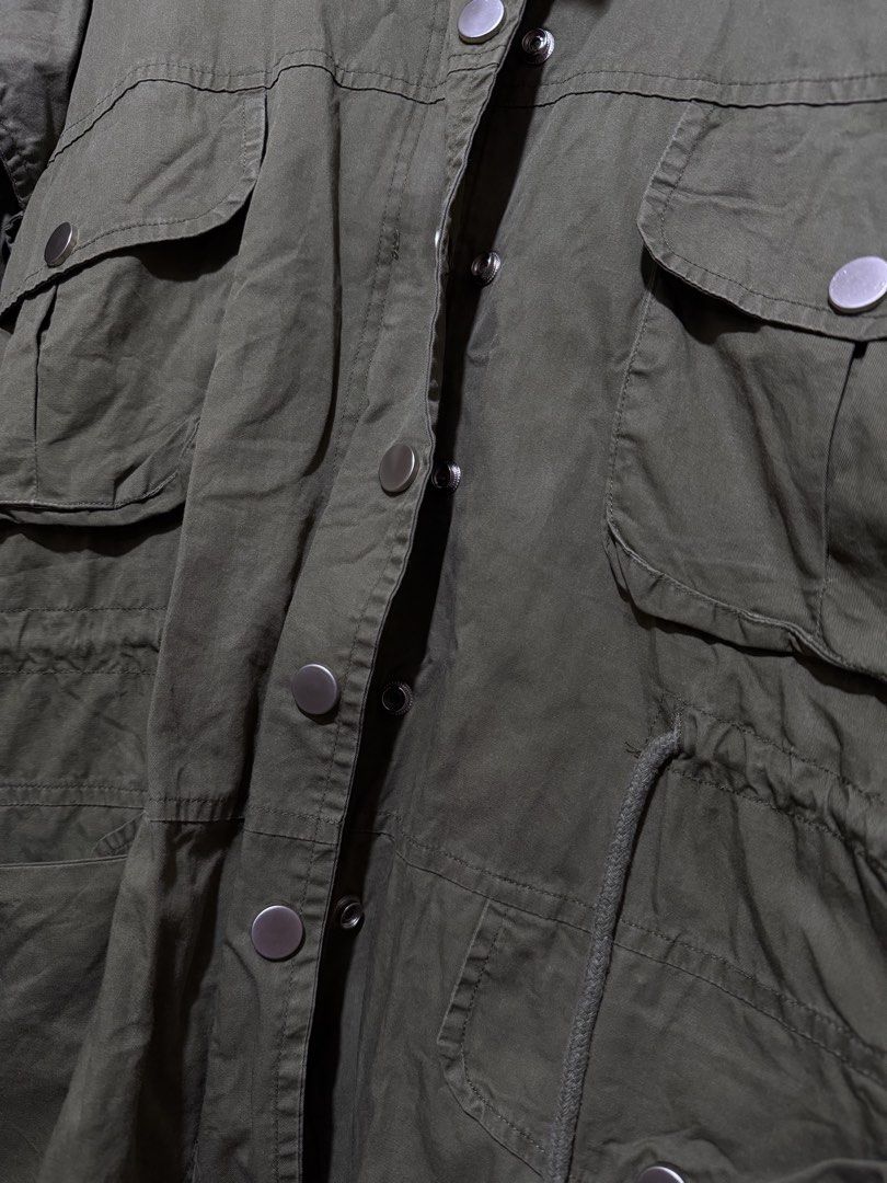 SML Green Utility Jacket Cargo Utility Outerwear (Category: Coats, Jackets and Outerwear) located in Marikina City. Submitted by switkimchi (Listing ID 1467629461, Image 2). Description: - Brand: SML - Color: Army green - Closure: Button-up front with metallic snaps - Pockets: Multiple cargo pockets on chest and lower front - Fit: Adjustable drawstring waist - Collar: High collar for wind protection - Ideal for: Layering, travel, and cooler weath