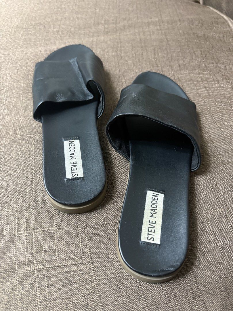 Steve Madden Black Slide Sandals (Category: Flats & Sandals) located in Cainta. Submitted by amswardrobe (Listing ID 1467837857, Image 2). Description: - Brand: Steve Madden - Color: Classic Black - Style: Slip-on slide sandals with wide foot strap and branded insole - Condition: Pre-loved with light wear around the toe edges - Features: Comfortable flat sole, ideal for daily casual wear.