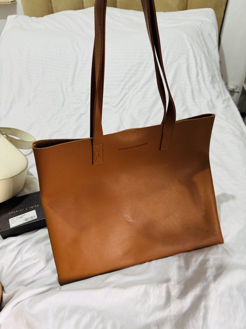 Straightforward Brown Leather Tote Bag (Category: Tote Bags) located in Pasig City. Submitted by marizanne04 (Listing ID 1467668060, Image 2). Description: - Brand: Straightforward - Material: Premium brown leather - Design: Open-top tote with sturdy shoulder straps - Storage: Roomy interior fits all daily essentials easily - Features: Inner pocket with magnetic snap closure and debossed logo - Condition: Clean finish inside and out, excellent ev