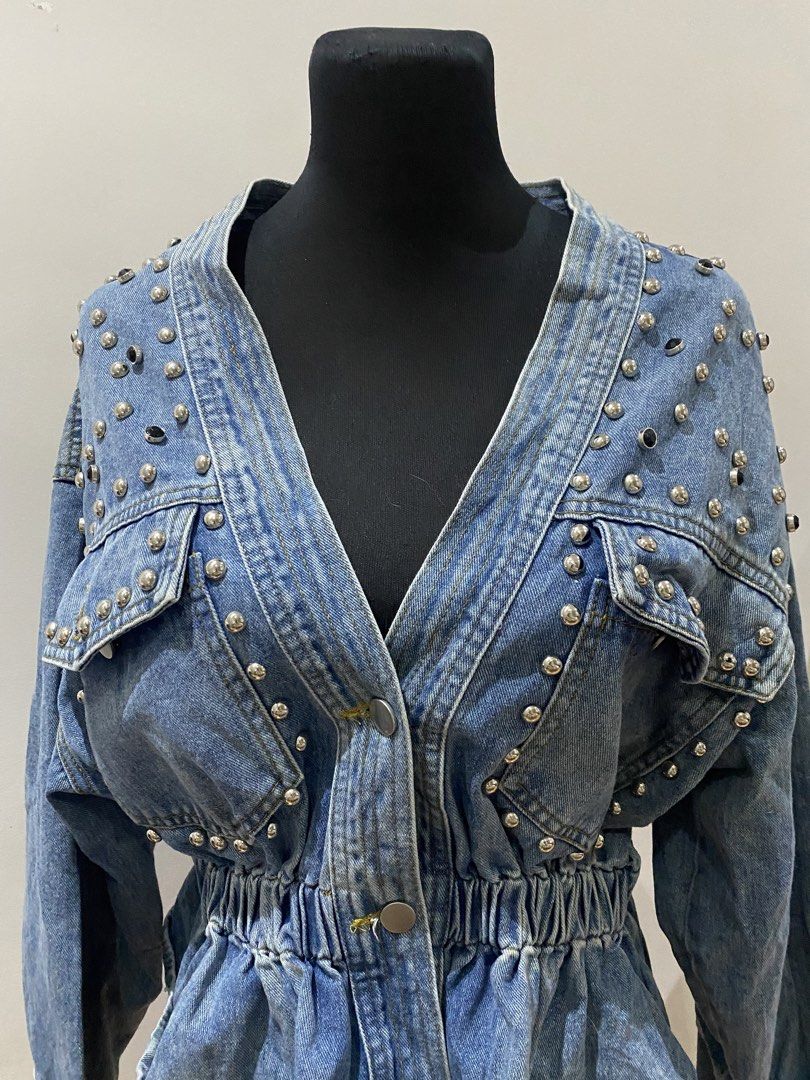 Studded Denim Jacket Peplum Waist V-Neck (Category: Coats, Jackets and Outerwear) located in Manila. Submitted by mpt99876 (Listing ID 1467796270, Image 2). Description: - Style: Statement medium wash denim jacket with silver metal hardware - Neckline: Deep V-neck with two front button closures - Fit: Cinched elastic waist with a stylish peplum flare - Pockets: Two chest pockets with button flaps - Details: Long sleeves with button cuffs and heav