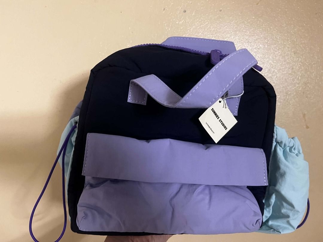 Sunnies Studios Kpop Demon Hunter Lunch Bag (Category: Backpacks) located in Pasay City. Submitted by julliadlion.1 (Listing ID 1467652978, Image 2). Description: - Brand: Sunnies Studios - Material: Lightweight puffy nylon - Features: Top zipper closure, front pocket flap, top handle, and drawstring side pockets - Condition: Brand new with original tag attached.
