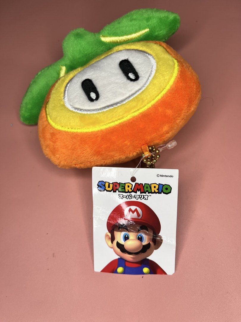 Super Mario Fire Flower Plush Coin Purse (Category: Purses & Pouches) located in Caloocan City. Submitted by snapshop_ph (Listing ID 1467645078, Image 2). Description: - Authentic Super Mario Fire Flower plush coin purse - Soft orange and yellow material with green leaf details - Secure zipper closure with orange mesh-lined interior - Includes golden ball chain strap and clasp for easy hanging on bags or keys - Comes with original hang tags (Grea