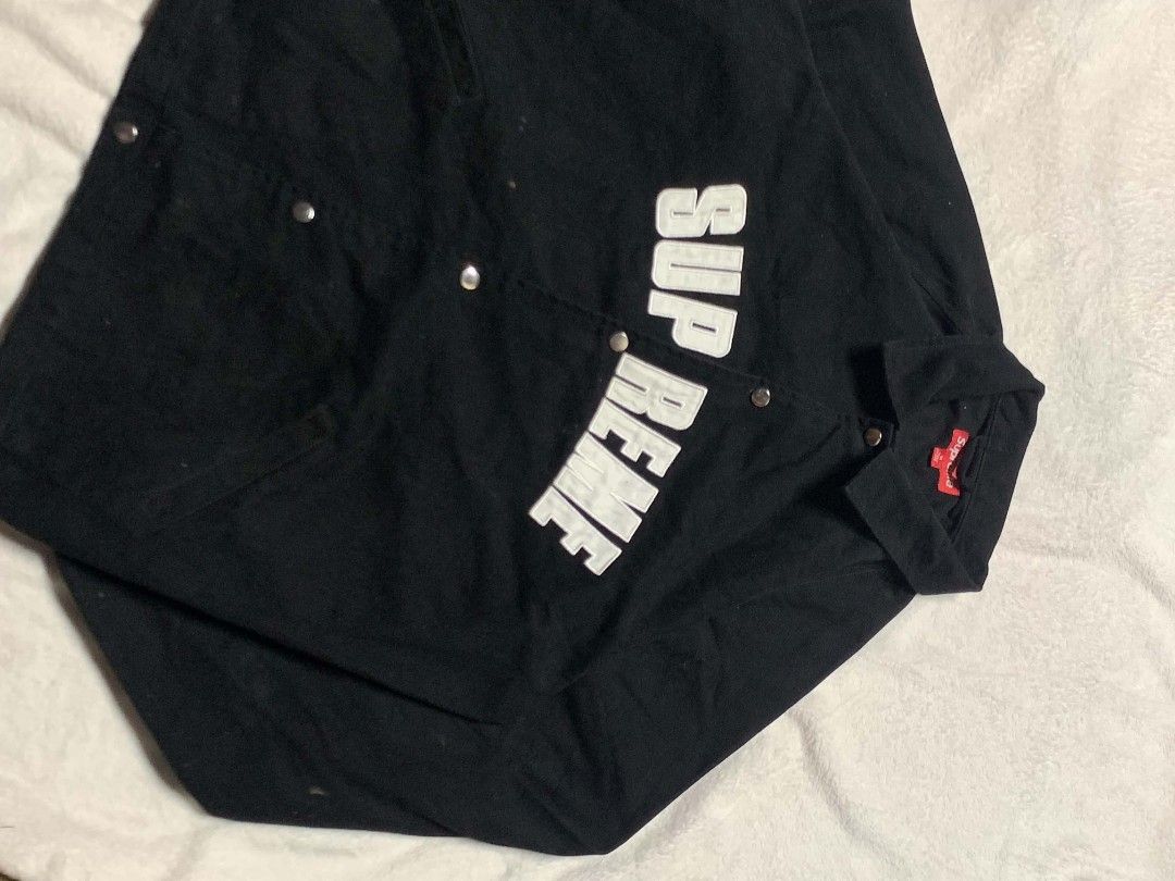 Supreme Black Canvas Snap Front Jacket Size M (Category: Coats, Jackets and Outerwear) located in San Juan City. Submitted by findmorelux (Listing ID 1467786685, Image 3). Description: - Brand: Supreme - Item: Black Canvas Jacket - Size: Medium - Condition: Clean, durable heavyweight fabric - Details: Bold white diagonal Supreme embroidery, classic fold-over collar, metallic snap buttons, and signature red box logo tag inside.