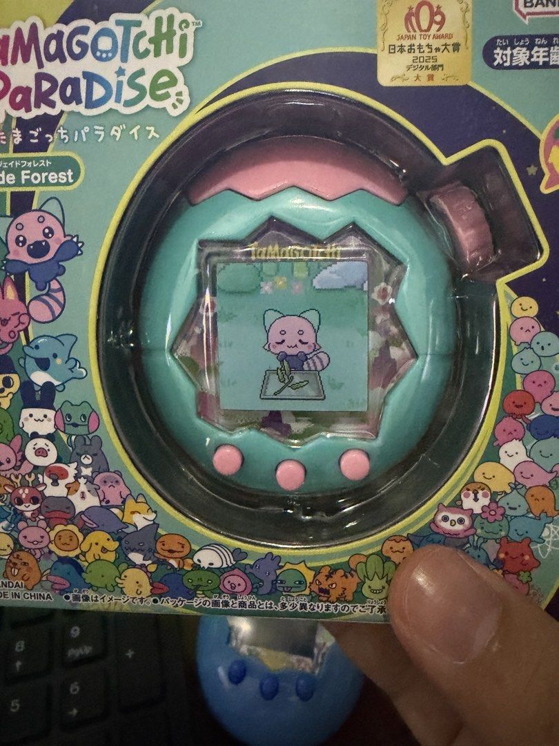 Tamagotchi Paradise Jade Forest (Category: Interactive Toys) located in Mandaluyong City. Submitted by raprap0302 (Listing ID 1467810862, Image 1). Description: - Brand: Bandai Namco - Edition: Tamagotchi Paradise - Jade Forest Edition (Japanese Toy Award Winner) - Design: Turquoise shell with cute pink top and buttons - Condition: Brand new, sealed, and intact box packaging - Perfect for collectors and Tamagotchi fans.