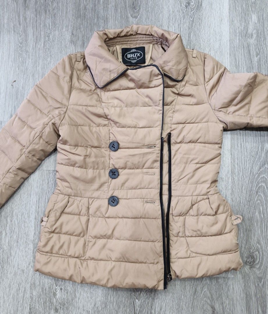Tan Puffer Jacket Winter Coat (Category: Coats, Jackets and Outerwear) located in Muntinlupa City. Submitted by prelovedbysandy (Listing ID 1467631303, Image 3). Description: - Brand/Model: BHZX Tan Quilted Puffer Jacket - Color: Versatile neutral khaki brown - Closure: Asymmetrical zipper with large black front buttons - Features: Collared neckline, ribbed black cuffs to block the cold, and front pockets - Fit: Pit-to-pit is approximately 18.5 i