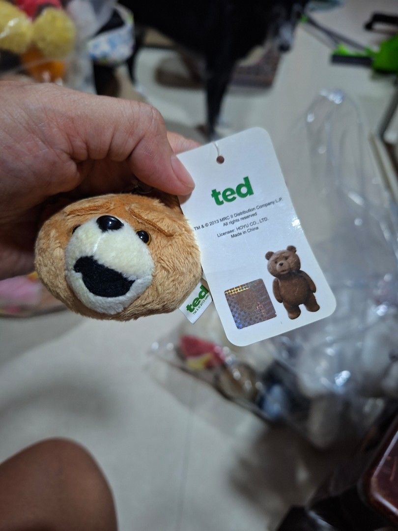 Ted Bear Plush Toy Keychain with Suction Cup (Category: Plushies & Soft Toys) located in Bulacan. Submitted by ourdailyfinds (Listing ID 1467736782, Image 1). Description: - Official Ted movie plush bear head - Comes with original cardboard tag and holographic sticker - Includes a hanging strap and suction cup on the back for easy display - White side tag reads TM and 2013 MRC - Made with soft brown fabric, white muzzle, and black mouth.