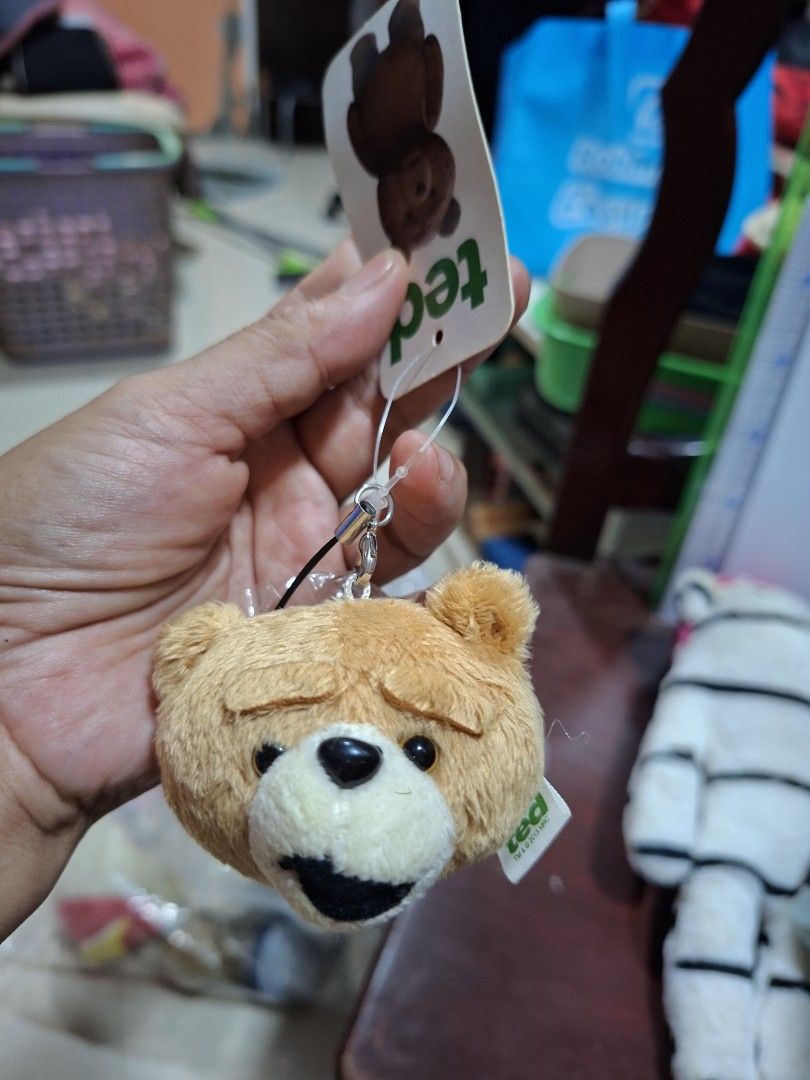 Ted Bear Plush Toy Keychain with Suction Cup (Category: Plushies & Soft Toys) located in Bulacan. Submitted by ourdailyfinds (Listing ID 1467736782, Image 2). Description: - Official Ted movie plush bear head - Comes with original cardboard tag and holographic sticker - Includes a hanging strap and suction cup on the back for easy display - White side tag reads TM and 2013 MRC - Made with soft brown fabric, white muzzle, and black mouth.