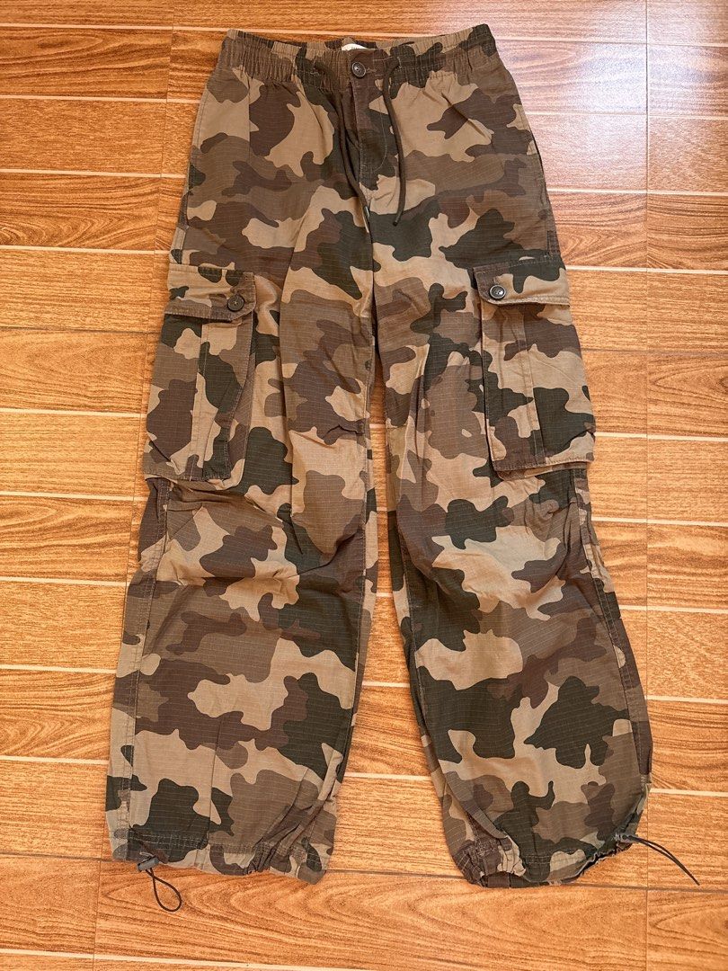 Terranova Camouflage Cargo Pants (Category: Jeans) located in Manila. Submitted by _foryou (Listing ID 1467672628, Image 1). Description: - Brand: Terranova - Design: Camouflage in green, brown, and tan tones - Size: ITA 40, USA 25, EU 36 - Material: Durable ripstop fabric - Waist: Elastic waistband with drawstring, button closure, and zip fly - Pockets: Functional cargo pockets on both thighs and back pockets with button flaps - Hem: Adjustable 