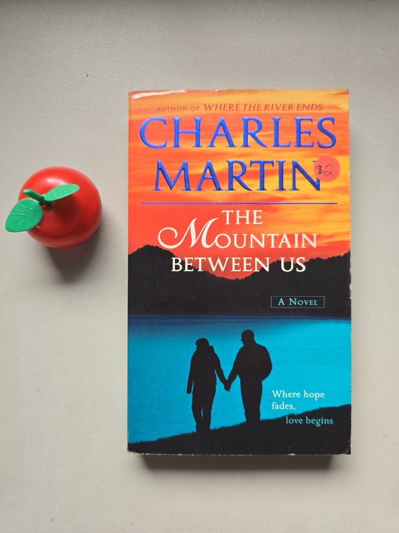 The Mountain Between Us by Charles Martin Novel (Category: Storybooks) located in Baguio. Submitted by genesisomega (Listing ID 1467684055, Image 1). Description: - Title: The Mountain Between Us - Author: Charles Martin - Format: Paperback novel - Cover: Sunset and blue silhouette with tagline 'where hope fades and love begins' - Condition: Readable pages intact, with a small red price sticker on the front cover - Perfect for fiction lovers and 