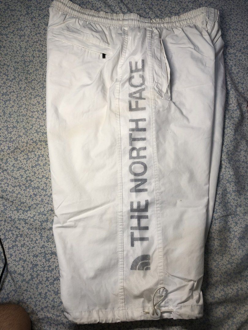 The North Face White Side Striped 3/4s (Category: Joggers) located in Caloocan City. Submitted by castroemman0201 (Listing ID 1467675308, Image 2). Description: - Brand: The North Face - Size: Tagged 105 - Color: White - Fit: Elastic waistband with adjustable drawstring hem at the bottom - Details: Bold mesh side panels with The North Face branding and embroidered logo near the front pocket - Pockets: Convenient zip pocket on the side with a bran